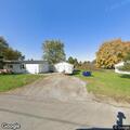 Man sitting on roadside in orange at Brentlinger Rd