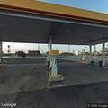 Small fuel spill near pond at gas station