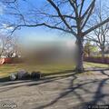 Man in green jacket tries house doorknob