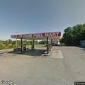 Adult male slumped over steering wheel at fuel mart