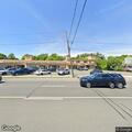 Suspicious vehicle with sleeping man behind store