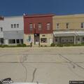Car blocks parking spaces and roadway near bar