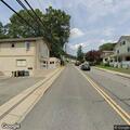 Dog tied to vehicle bumper in roadway