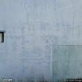 Suspicious man hunched over by house on Main Street