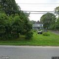 Woman taking photos from gray sedan on Mahopac Ave
