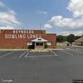 Car smoking under hood at bowling alley lot