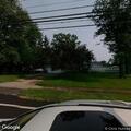 Broken down gray sedan blocking driveway