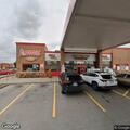 Officer checks parked vehicle at gas station
