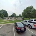 Car driving on grass behind Riverside Park apartments
