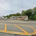 Dumpster fire against building at auto shop
