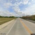 Female walking impaired on shoulder near highway overpass