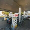 Person asleep in running car at gas station