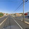 Person checked by officer near laundromat in rain