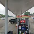 Woman experiencing asthma attack in vehicle at gas station