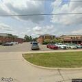 Man hanging from roof looking into apartment window