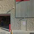 Minivan on fire near store entrance driveway