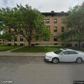 Man looking into parked cars at apartments