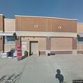 Woman with child rummaging through garbage outside store