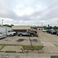 Person under car at auto shop parking lot