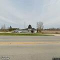 Person lying down in grass behind property on highway 45