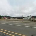 Slow green flatbed truck driving in wrong lane