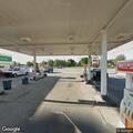 Woman experiencing breathing difficulty behind gas station