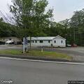 Man standing in road near Macy's Hair Salon in Boothbay