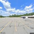 Officer checks parked vehicle at store lot