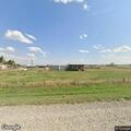 Grass fire spreading near vehicles on North 18th Road