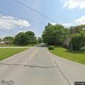 Woman walking in road waving arms in Cartersburg