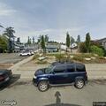 Man taking trash bags from dumpster in apartment lot