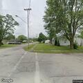 Person sitting dangerously close to street at intersection