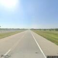 Person sitting on highway shoulder, possibly unwell