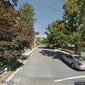 Elderly man assisted from car to wheelchair at dialysis center
