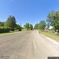Black pickup speeds toward school on Henderson St