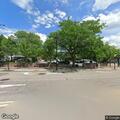 Officer checks man in dark shirt at Harris and Harvard