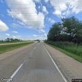 Pedestrian sitting on I-80 shoulder guardrail