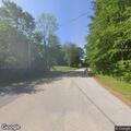 Tree limb blocking road and resting on utility wires