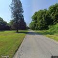 Person unresponsive in gray car at cemetery