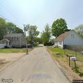 Woman walking unusually near cemetery and bus stop