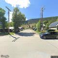 People gather near bear family behind fence