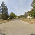 Man walking in roadway in only shorts and slides