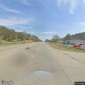 Tree leaning into roadway and power lines