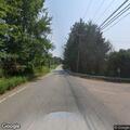 Pedestrian walking away from school bus on Route 85