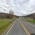 Woman sitting in grass area at Old National Pike checked
