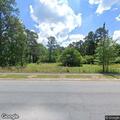 Debris fire spreading toward woods on North Jones Road