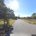 Tree limb hanging over road with debris below