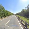 Motorist waves cow from van on highway side