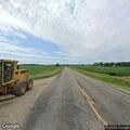 Officer checks abandoned vehicle at rural intersection