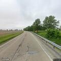 Pedestrian standing confused on Illinois 16 near auto sales